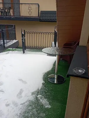 a patio with a table and snow on the ground at Willa Babia Góra in Zawoja