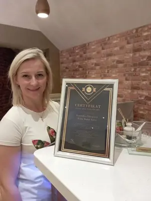a woman sitting at a counter with a framed picture at Willa Babia Góra in Zawoja