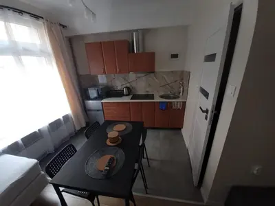 a small kitchen with a table and chairs in a room at KĄCIK Apartament in Kraków