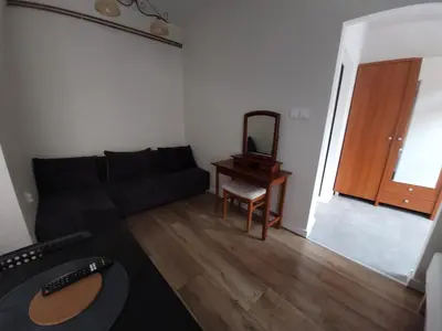 a living room with a black couch and a mirror at KĄCIK Apartament in Kraków