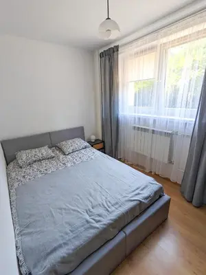 a bed in a bedroom with a large window at Apartament Jabłko-Mięta w Tymbarku in Tymbark