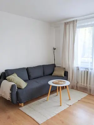 a living room with a blue couch and a table at Apartament Jabłko-Mięta w Tymbarku in Tymbark