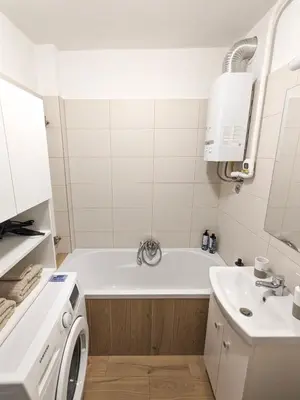 a bathroom with a tub and a sink and a washing machine at Apartament Jabłko-Mięta w Tymbarku in Tymbark