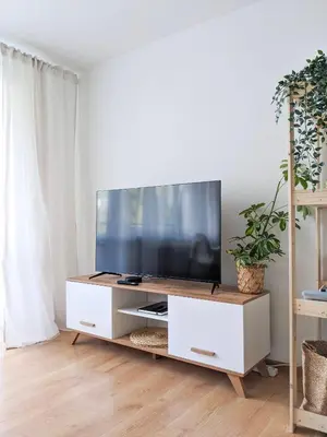 a living room with a flat screen tv on a white entertainment center at Apartament Jabłko-Mięta w Tymbarku in Tymbark
