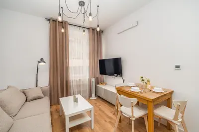 a living room with a couch and a table with a dining room at Kraków Główny Apt - Top Location, Park&Tram nearby - by Rentujemy in Kraków