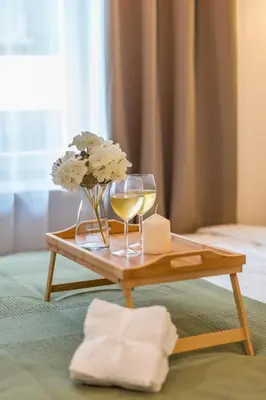 a table with a glass of wine and flowers on it at Kraków Główny Apt - Top Location, Park&Tram nearby - by Rentujemy in Kraków