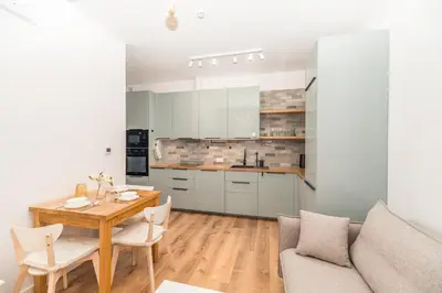 a kitchen and living room with a table and a couch at Kraków Główny Apt - Top Location, Park&Tram nearby - by Rentujemy in Kraków
