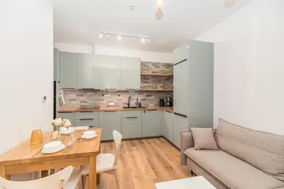 a kitchen and living room with a table and a couch at Kraków Główny Apt - Top Location, Park&Tram nearby - by Rentujemy in Kraków