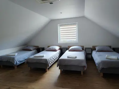 three beds in a room with a window at Domek na Dogalu in Filipowice