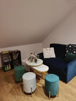 a living room with a couch and a table andools at Domek na Dogalu in Filipowice