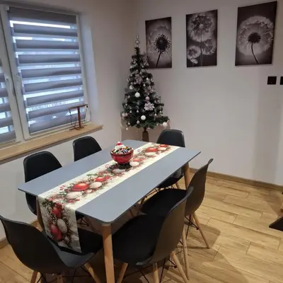 a dining room table with a christmas tree in the background at Domek na Dogalu in Filipowice