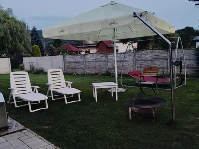 a group of chairs and an umbrella in a yard at Domek na Dogalu in Filipowice
