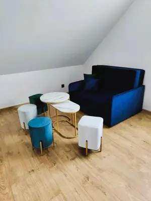 a living room with a couch and a table andools at Domek na Dogalu in Filipowice
