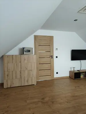 an attic room with a closet and a door at Domek na Dogalu in Filipowice
