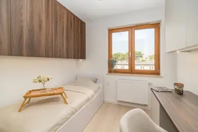 a living room with a couch and a table at Kraków Prestige Suites - 61m2, Parking, Balcony, Workspace, AC - by Rentujemy in Kraków