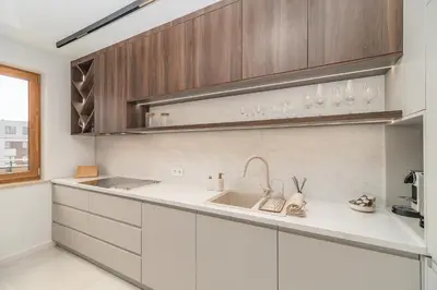 a kitchen with white cabinets and a sink at Kraków Prestige Suites - 61m2, Parking, Balcony, Workspace, AC - by Rentujemy in Kraków