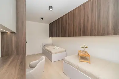 a living room with a bed and a table at Kraków Prestige Suites - 61m2, Parking, Balcony, Workspace, AC - by Rentujemy in Kraków