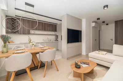 a living room with a table and a couch at Kraków Prestige Suites - 61m2, Parking, Balcony, Workspace, AC - by Rentujemy in Kraków