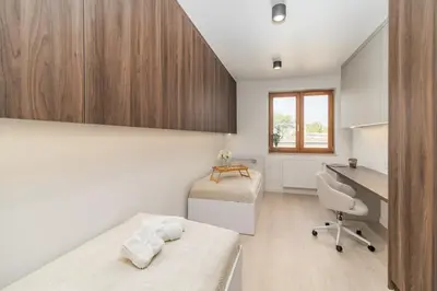 a bedroom with a bed and a desk and a desk at Kraków Prestige Suites - 61m2, Parking, Balcony, Workspace, AC - by Rentujemy in Kraków