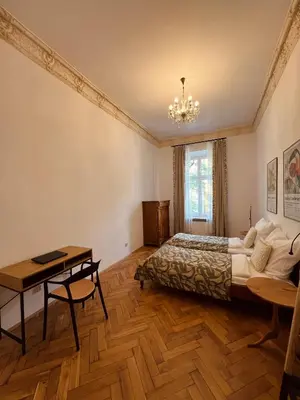 a bedroom with a bed and a table and a desk at Apartament Róży in Kraków