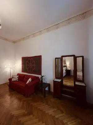 a living room with a red couch and a mirror at Apartament Róży in Kraków