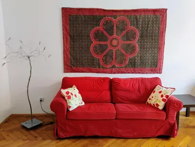 a red couch in a living room with a rug at Apartament Róży in Kraków