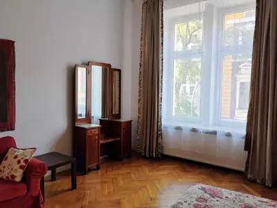 a living room with a large window and a red couch at Apartament Róży in Kraków