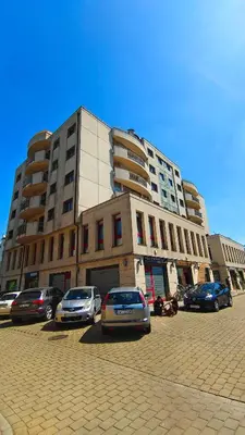 a large building with cars parked in front of it at Bronowicka Comfort Apartment in Kraków