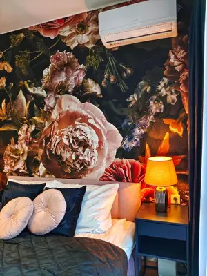 a bedroom with a flower mural on the wall at Bronowicka Comfort Apartment in Kraków