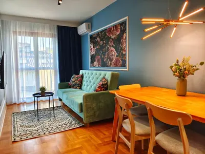 a living room with a green couch and a table at Bronowicka Comfort Apartment in Kraków
