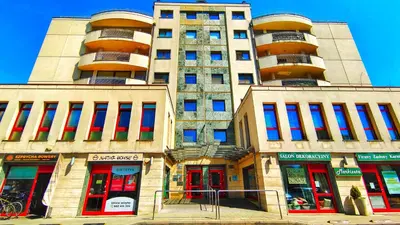 a tall building with red and blue windows at Bronowicka Comfort Apartment in Kraków
