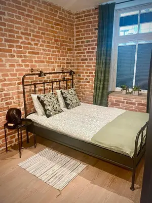 a bed in a room with a brick wall at Cracovia Kazimierz Historic Heart Accessible Apartament in Kraków