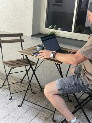 a man sitting at a table with a laptop at Cracovia Kazimierz Historic Heart Accessible Apartament in Kraków