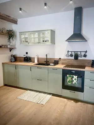a kitchen with white cabinets and a stove top oven at Cracovia Kazimierz Historic Heart Accessible Apartament in Kraków