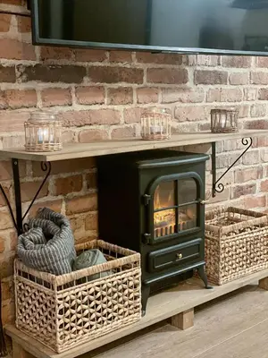 a fireplace in a living room with a stone wall at Cracovia Kazimierz Historic Heart Accessible Apartament in Kraków