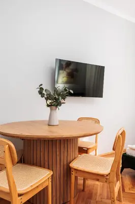 a table with chairs and a vase with a plant on it at Retro Glamour with a Modern Edge - by Upstairs in Kraków
