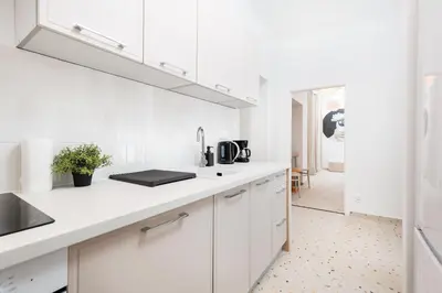 a white kitchen with white cabinets and a sink at Retro Glamour with a Modern Edge - by Upstairs in Kraków