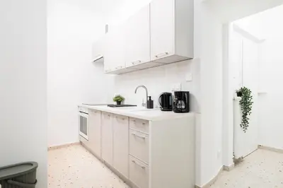 a white kitchen with white cabinets and a sink at Retro Glamour with a Modern Edge - by Upstairs in Kraków