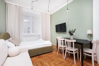 a living room with a bed and a table and chairs at Retro Glamour with a Modern Edge - by Upstairs in Kraków
