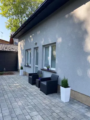a patio with couches and plants in front of a house at Apartamenty Lawenda in Kraków