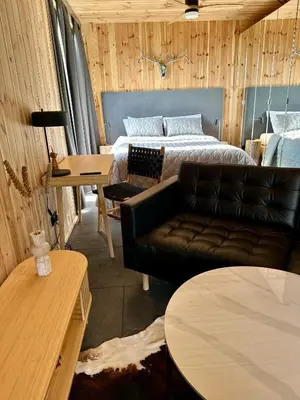 a dining room with a wooden table and chairs at Black Deer - z Sauną na Tarasie, Jacuzzi i Widokiem na Góry - by Deer Hills Luxury Apartments in Kocoń