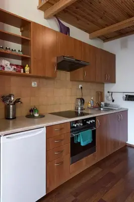 a kitchen with wooden cabinets and a stove top oven at Colour-Box Studio, Wawel Castle Area in Kraków