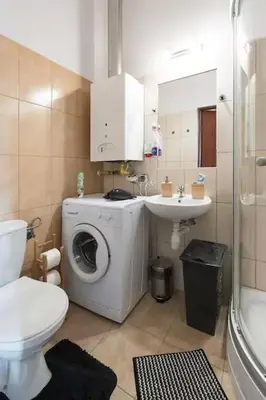 a bathroom with a washing machine and a sink at Colour-Box Studio, Wawel Castle Area in Kraków
