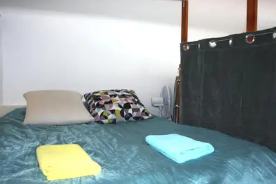 a bed with two towels on top of it at Smallest Spot in Town, City Center in Kraków