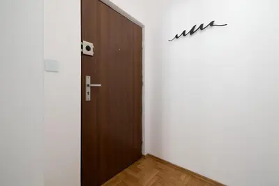 a hallway with a wooden door in a room at 1-bedroom Apartment - Radziwiłłowska 14 Street in Kraków