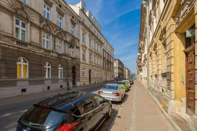 a row of cars parked on a street next to buildings at 1-bedroom Apartment - Radziwiłłowska 14 Street in Kraków