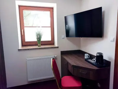 a room with a desk with a television and a window at Beskidia - Noclegi w Beskidach in Roczyny