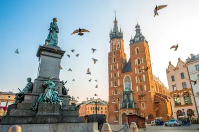 a statue in the middle of a city with birds at Prestiżowy apartament A free parking in Kraków