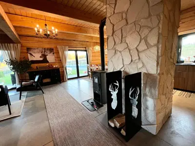 a living room with a stone wall with a fireplace at Kowalowa Chata Zawoja in Zawoja