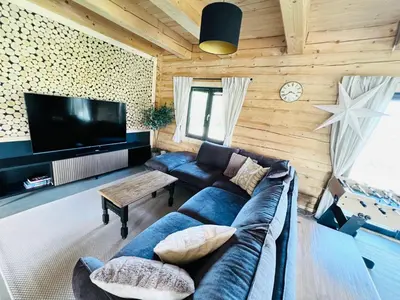 a living room with a blue couch and a tv at Kowalowa Chata Zawoja in Zawoja